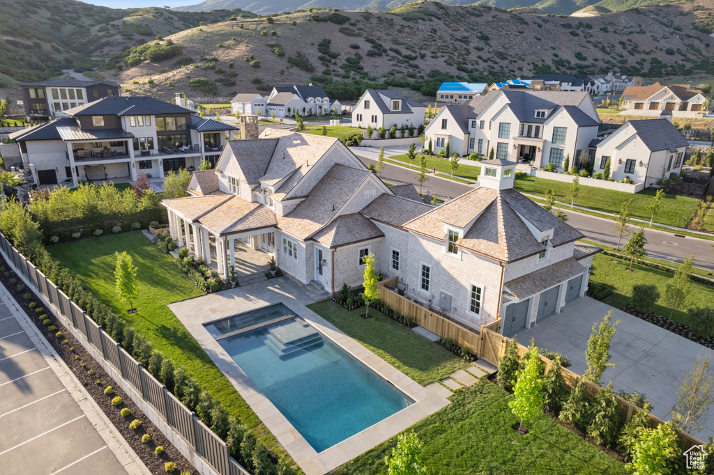 Aerial perspective of suburban area featuring mountains and a pool