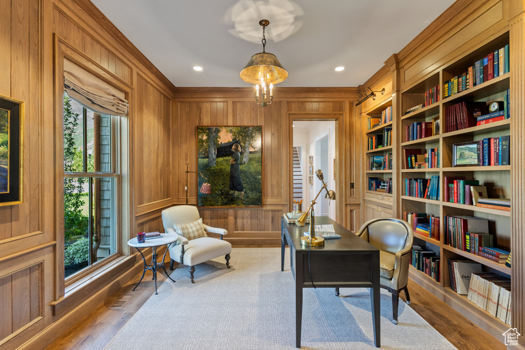 Office featuring wood walls, wood finished floors, built in features, and ornamental molding