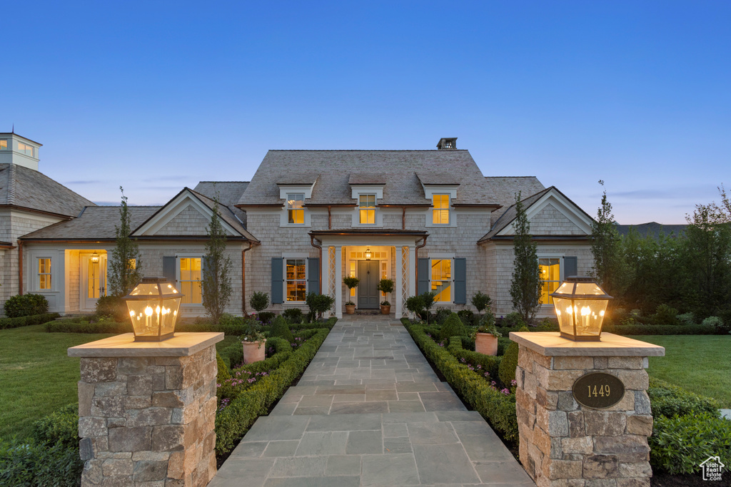 French provincial home with a chimney and a front lawn