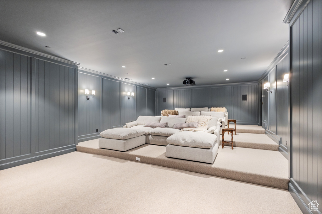 Home theater room featuring a decorative wall, carpet, ornamental molding, and recessed lighting