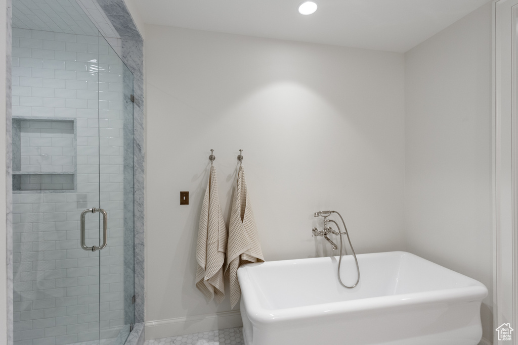 Full bathroom with a freestanding bath, baseboards, a stall shower, and recessed lighting