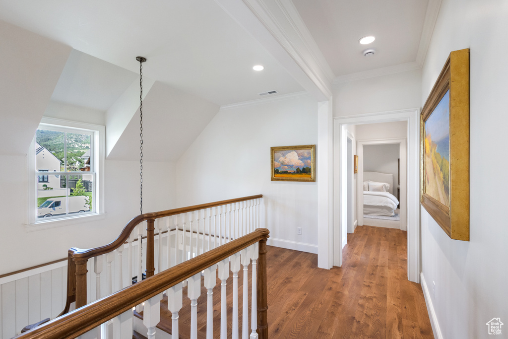 Hall featuring an upstairs landing, light wood-type flooring, crown molding, recessed lighting, and baseboards