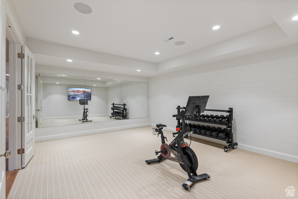 Exercise room featuring carpet flooring, baseboards, recessed lighting, and a tray ceiling