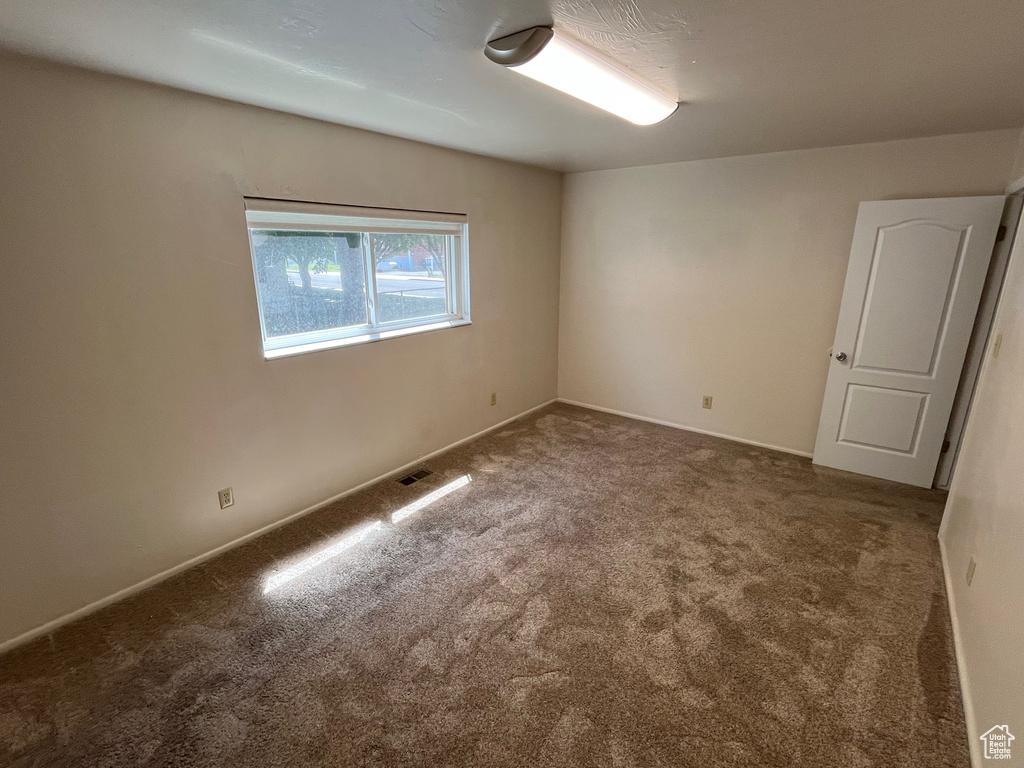 Carpeted empty room with baseboards