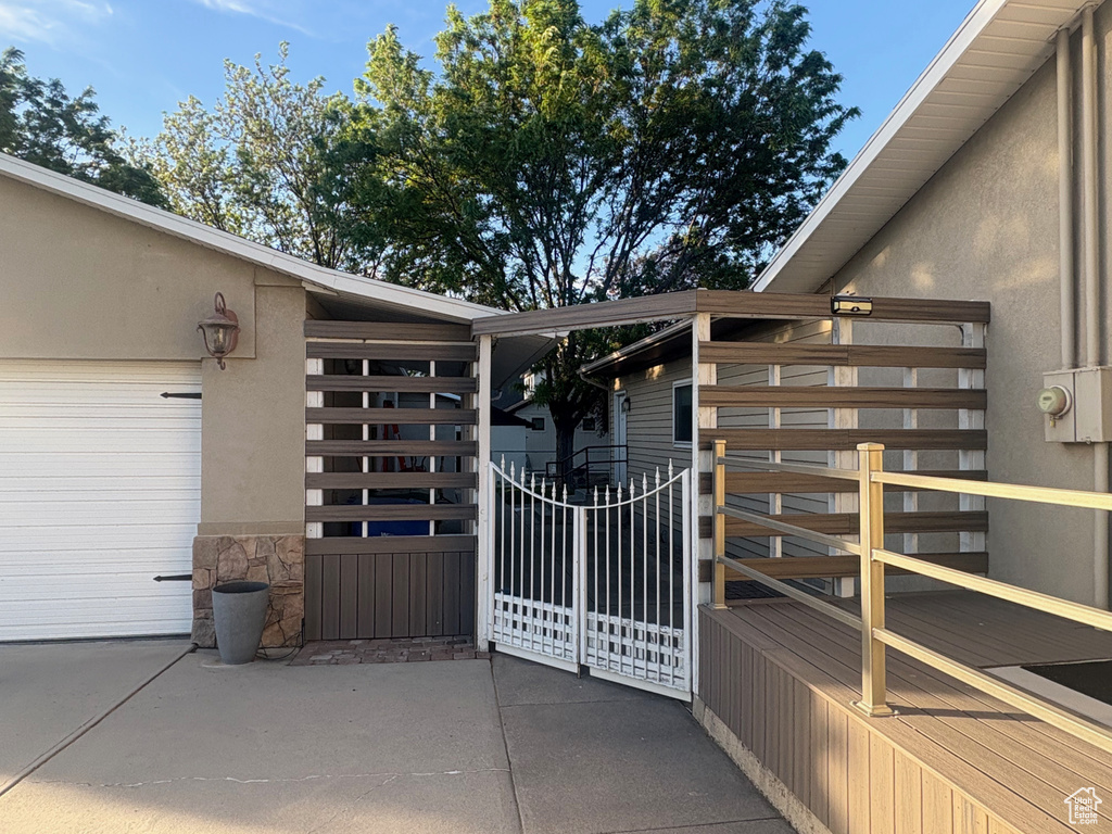 Entrance to property featuring a garage, stucco siding, stone siding, and driveway
