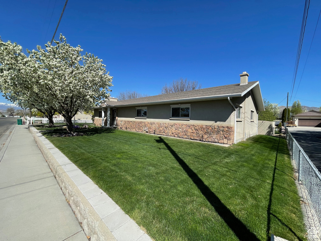 Single story home with stucco siding, stone siding, and a chimney