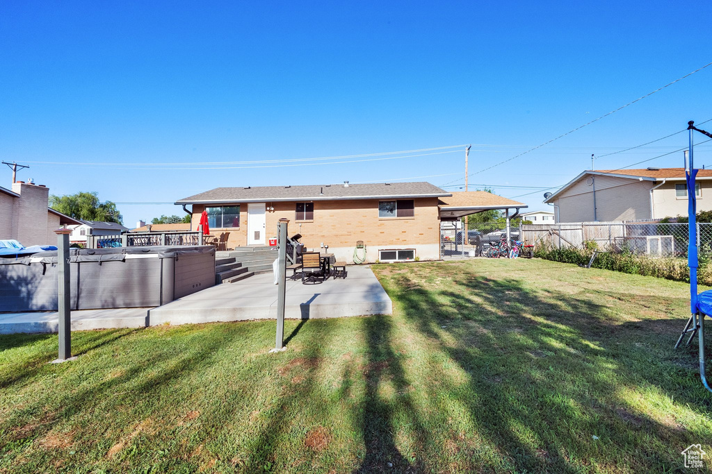 Back of house featuring a patio and a hot tub