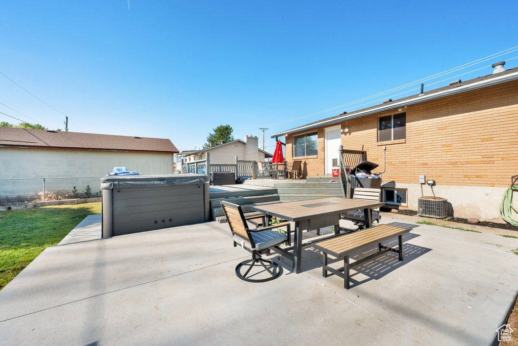 View of patio / terrace featuring a hot tub and outdoor dining area