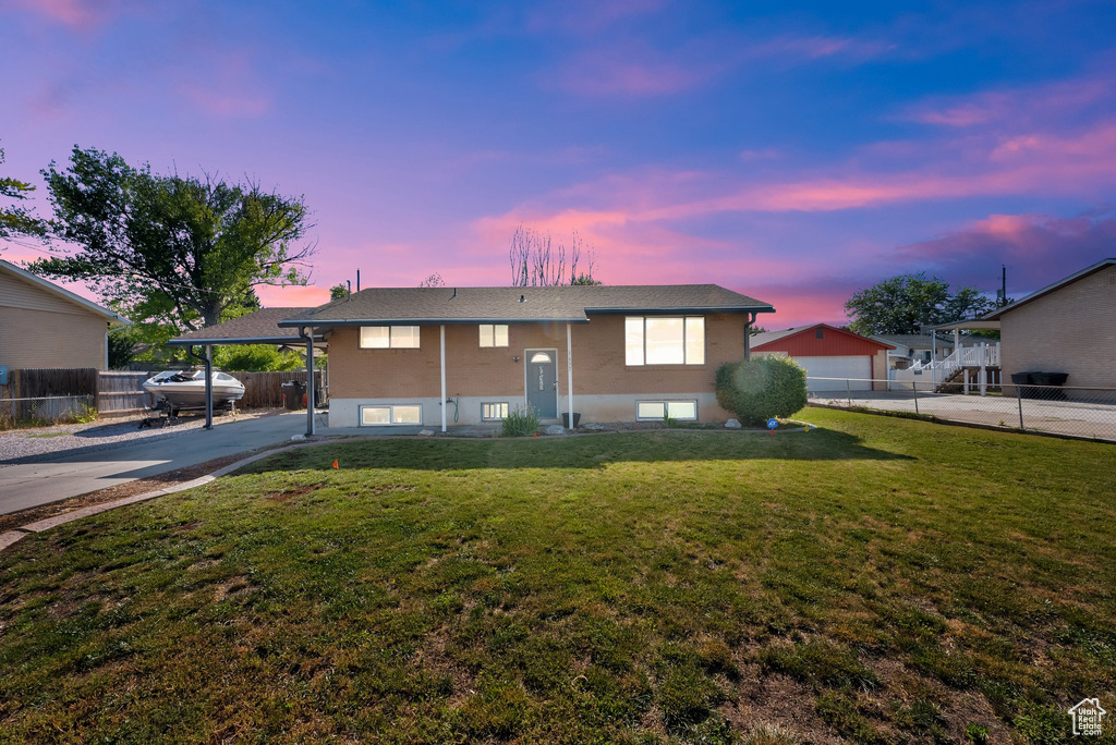Split foyer home featuring concrete driveway and a carport