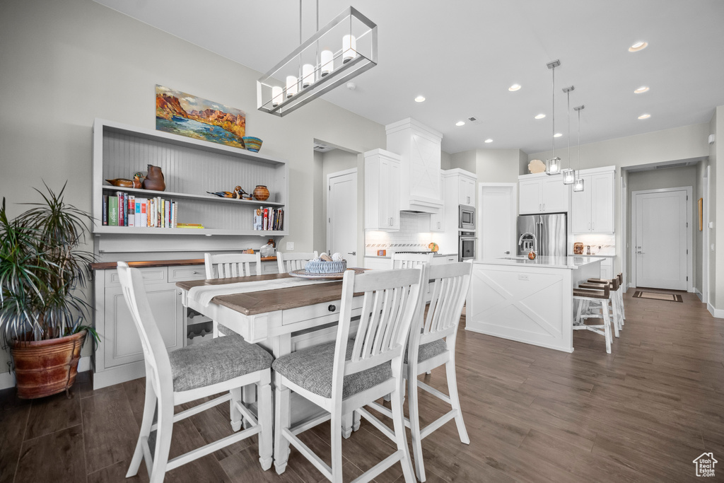 Dining space with dark wood-style flooring and recessed lighting