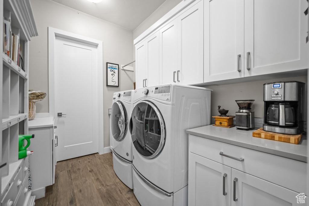 Washroom with independent washer and dryer, cabinet space, and dark wood finished floors