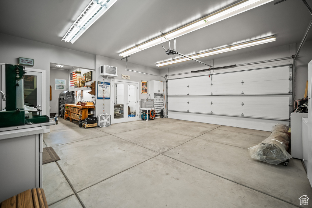 Garage featuring a garage door opener and an AC wall unit