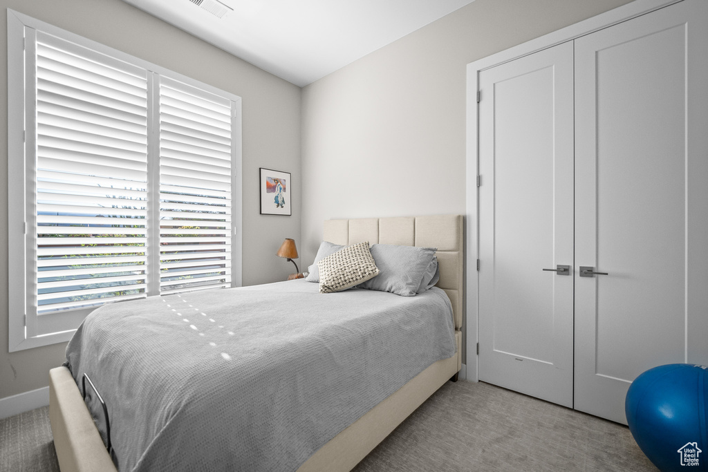 Carpeted bedroom with a closet and baseboards