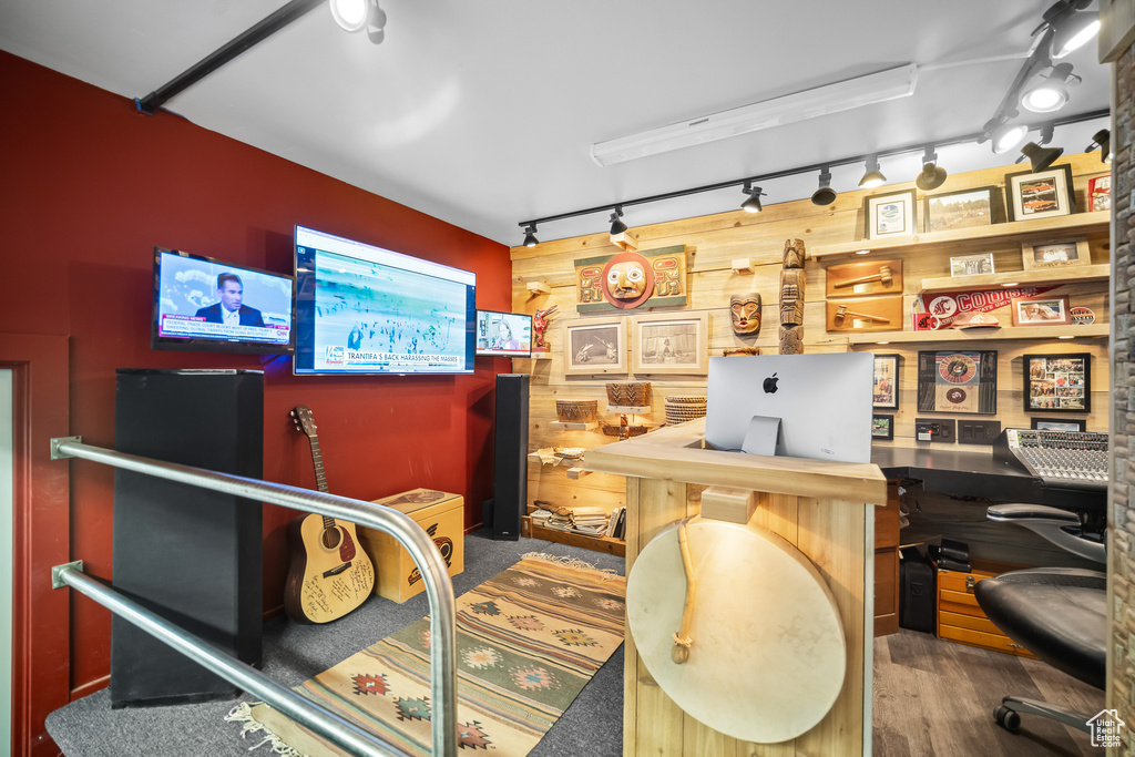 Office area with rail lighting, wood walls, and wood finished floors