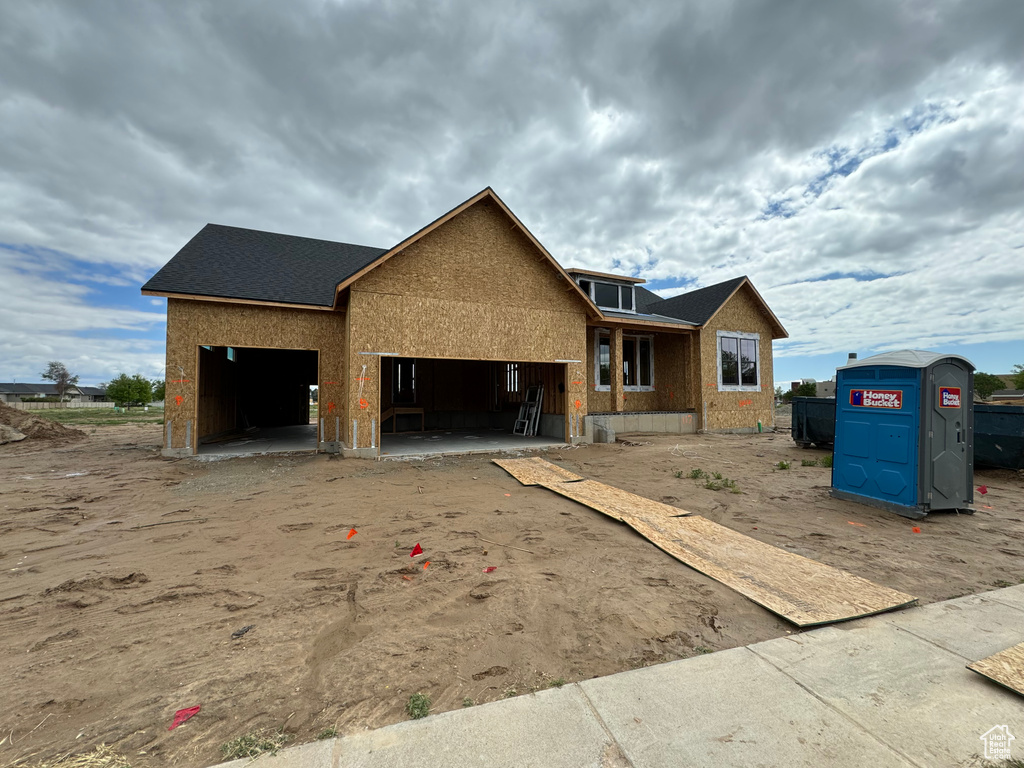 Property in mid-construction with an attached garage and roof with shingles