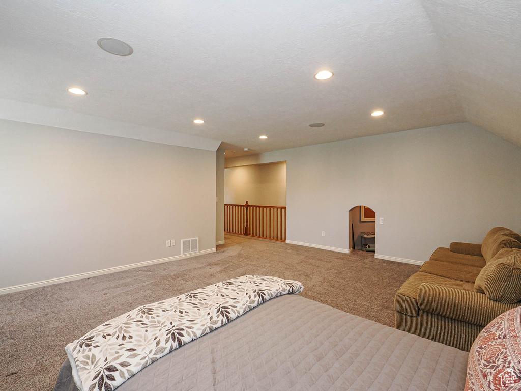 Bedroom featuring carpet floors, arched walkways, recessed lighting, baseboards, and vaulted ceiling