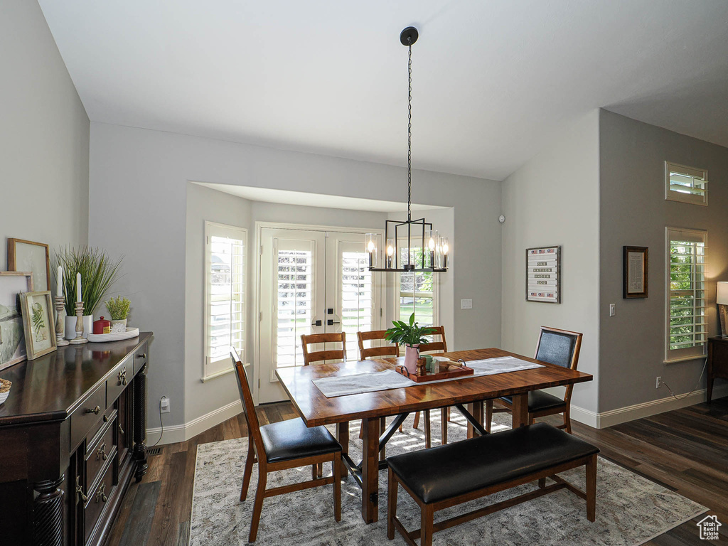 Dining area featuring a chandelier, baseboards, and dark wood finished floors