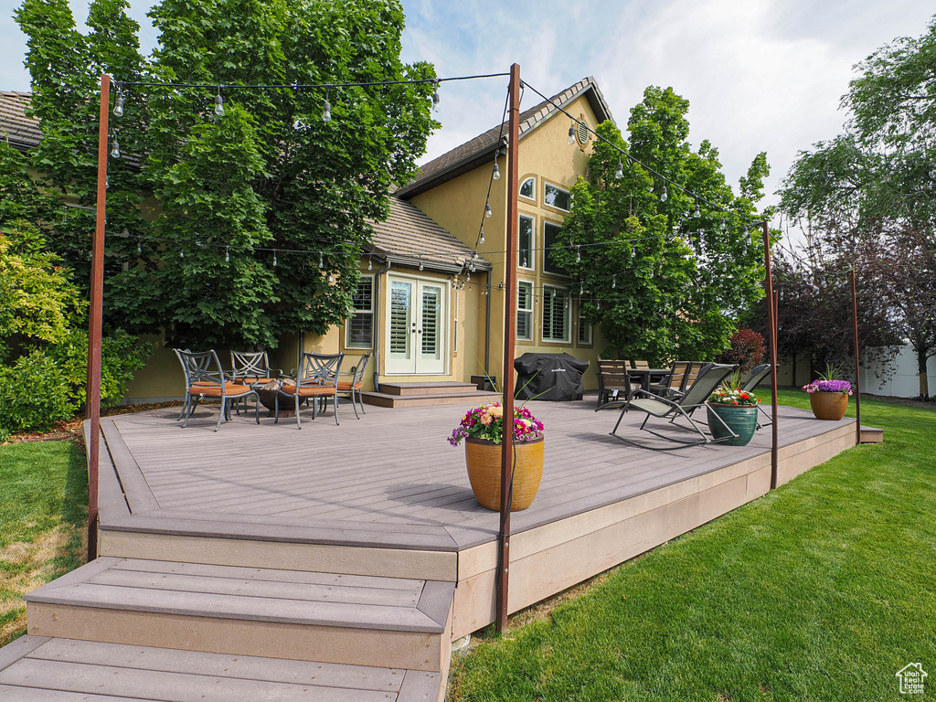 Wooden terrace with french doors and a yard