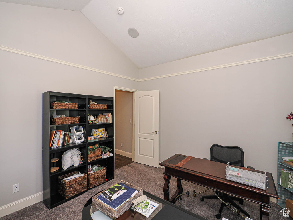 Carpeted home office with baseboards and high vaulted ceiling