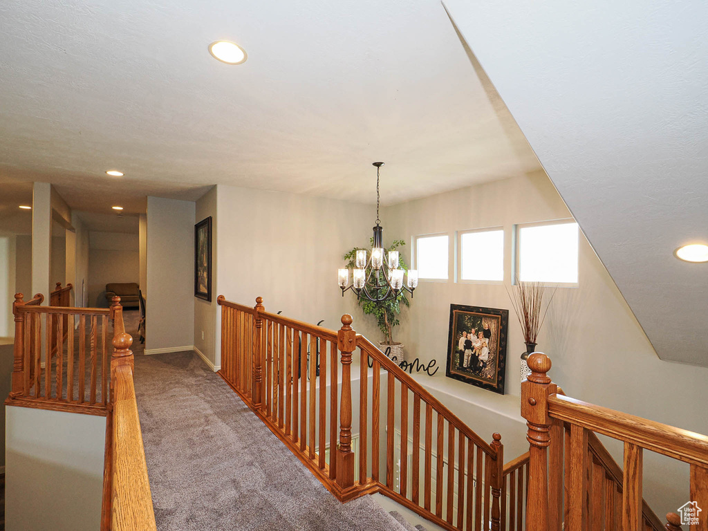 Hall with an upstairs landing, carpet flooring, a chandelier, recessed lighting, and baseboards