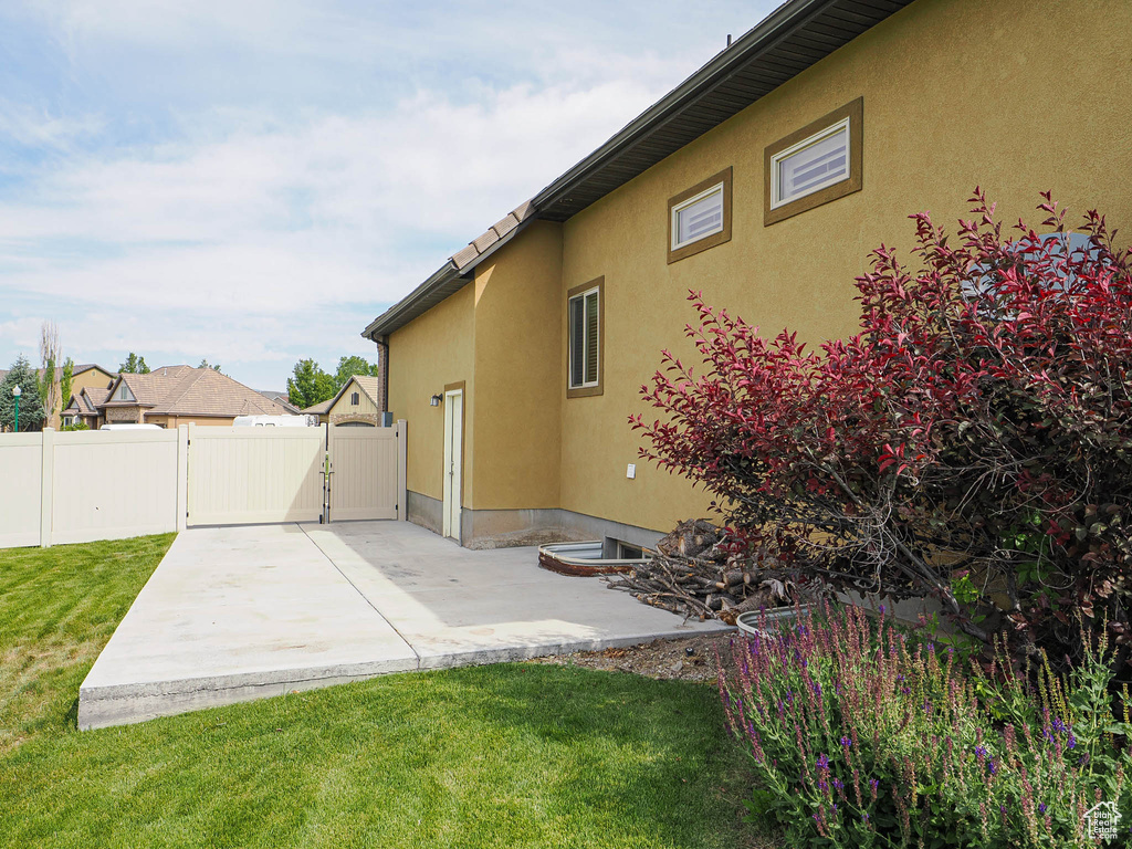 Back of house with a gate, a patio, and stucco siding