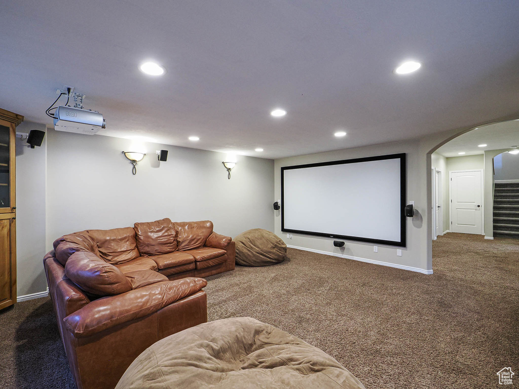 Home theater room with carpet floors, recessed lighting, arched walkways, and baseboards