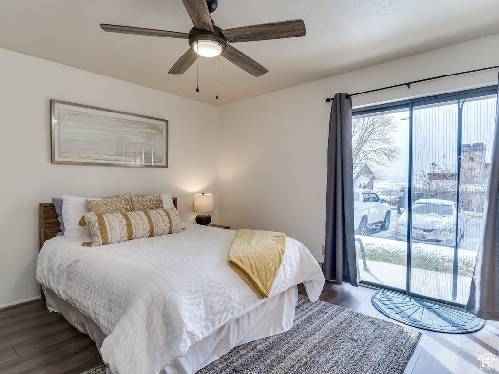 Bedroom featuring access to outside, wood finished floors, and ceiling fan