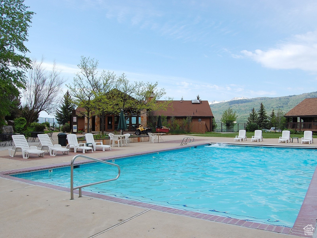 Community pool featuring a mountain view and a patio