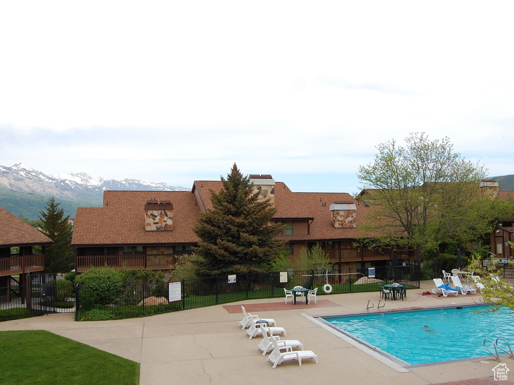 Community pool with a patio area and a mountain view