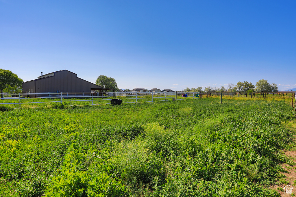 View of yard with a rural view, a pole building, and an outdoor structure