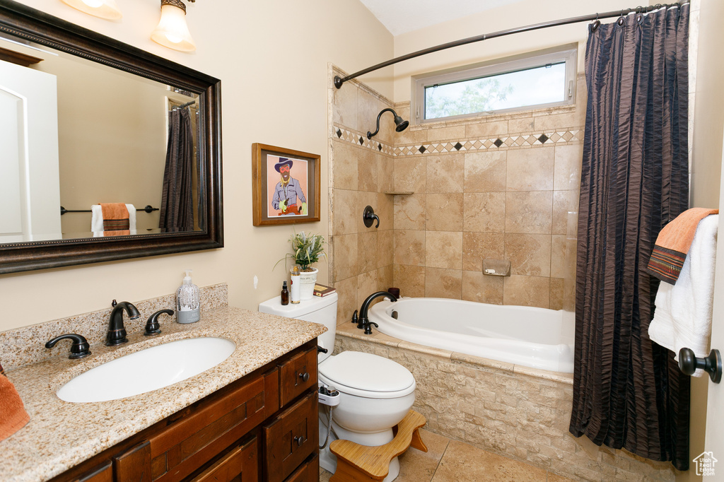 Full bath with tiled shower / bath combo, toilet, vanity, and tile patterned flooring