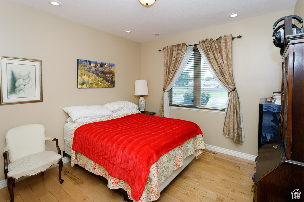 Bedroom with baseboards, wood finished floors, and recessed lighting