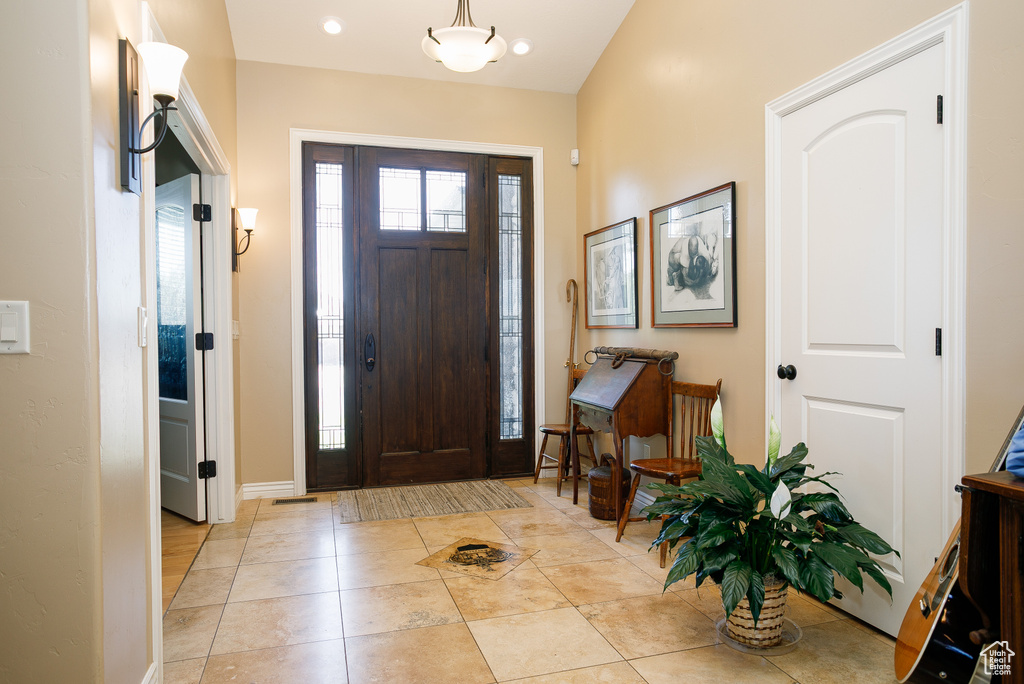 Entryway featuring baseboards and light tile patterned floors
