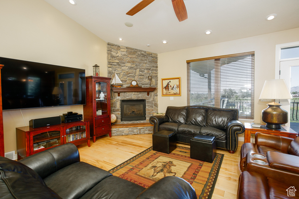 Living room with ceiling fan, wood finished floors, a fireplace, lofted ceiling, and recessed lighting