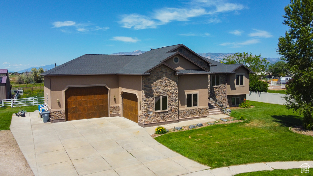 View of front of home with stone siding, stucco siding, and an attached garage