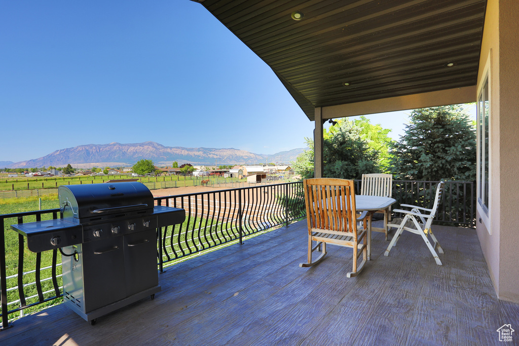 Deck with a mountain view, grilling area, and a rural view