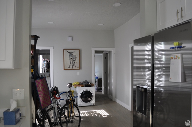 Laundry area with wood finished floors, baseboards, and recessed lighting
