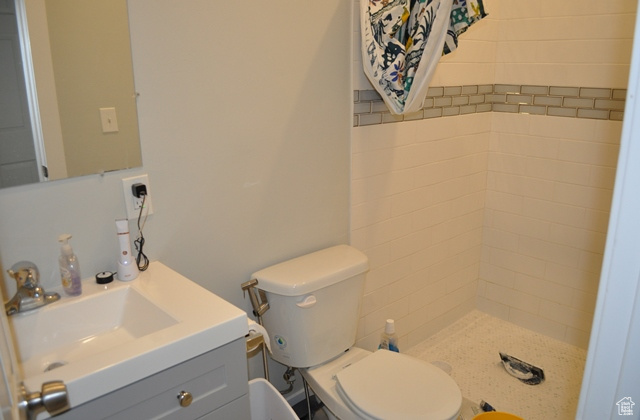Full bathroom with a stall shower, vanity, and toilet