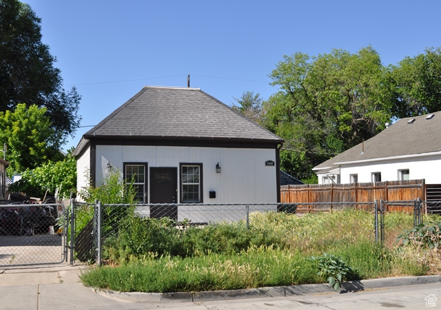 Rear view of property featuring a gate and roof with shingles