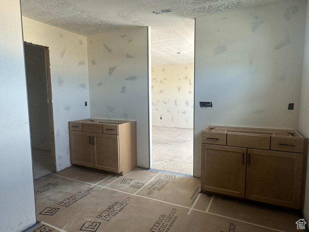Bathroom featuring a textured ceiling and vanity