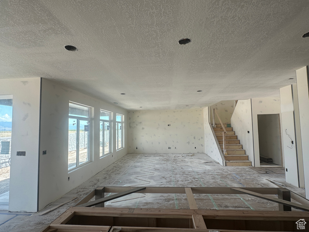 Unfurnished room with a textured ceiling and stairs