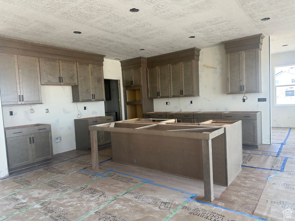 Kitchen with a kitchen island and a textured ceiling