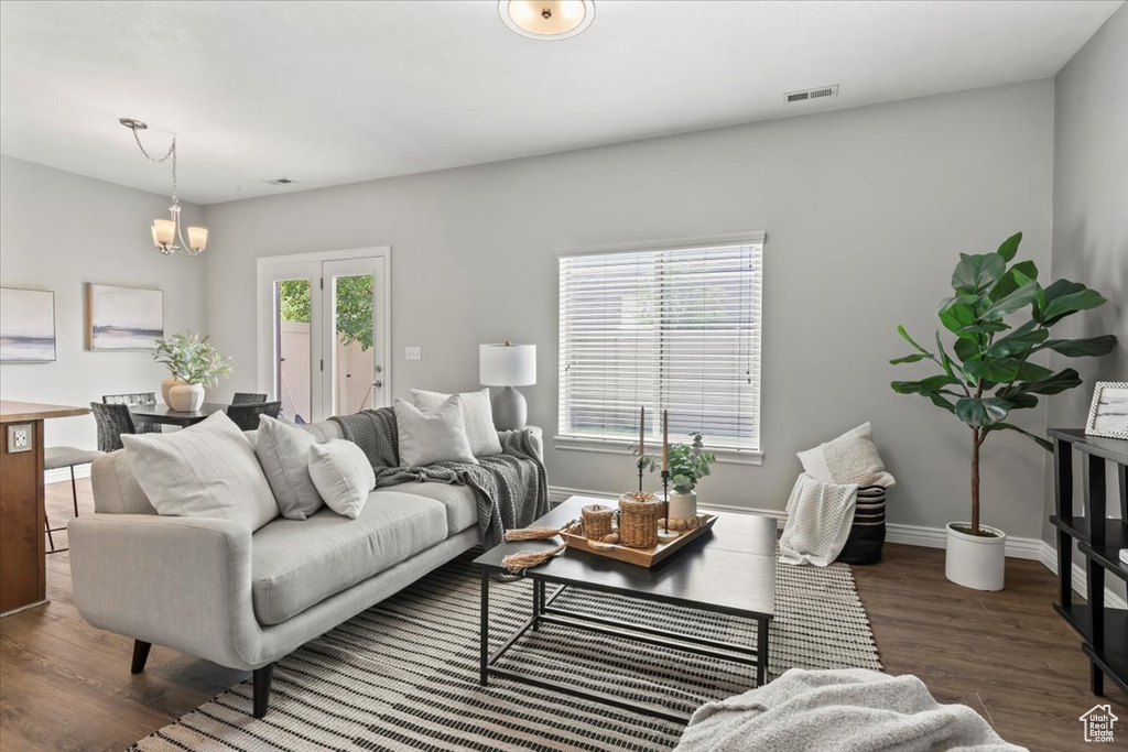 Living area featuring wood finished floors, baseboards, and a chandelier
