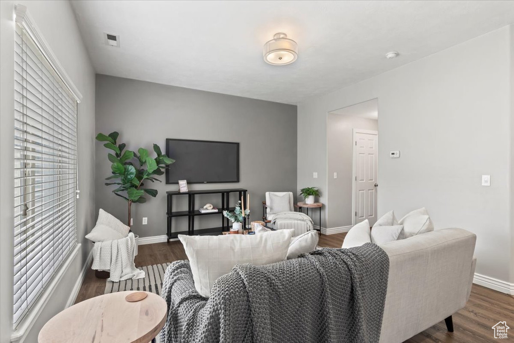Living area featuring dark wood-type flooring and baseboards