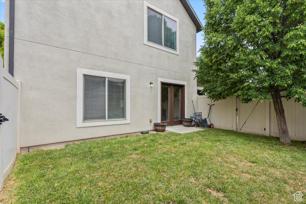 Rear view of property featuring stucco siding and french doors