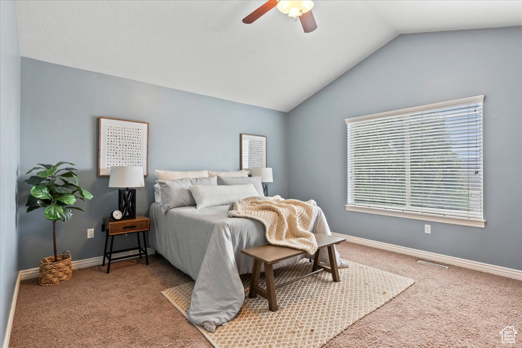 Carpeted bedroom with multiple windows, lofted ceiling, baseboards, and ceiling fan
