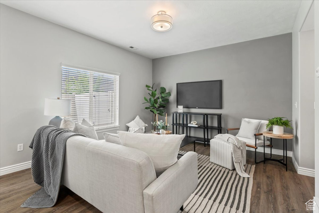 Living area featuring baseboards and dark wood-style floors