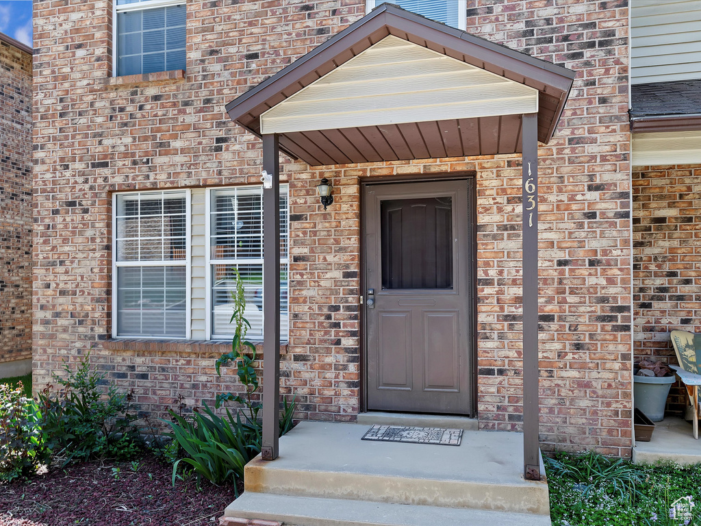 View of exterior entry featuring brick siding