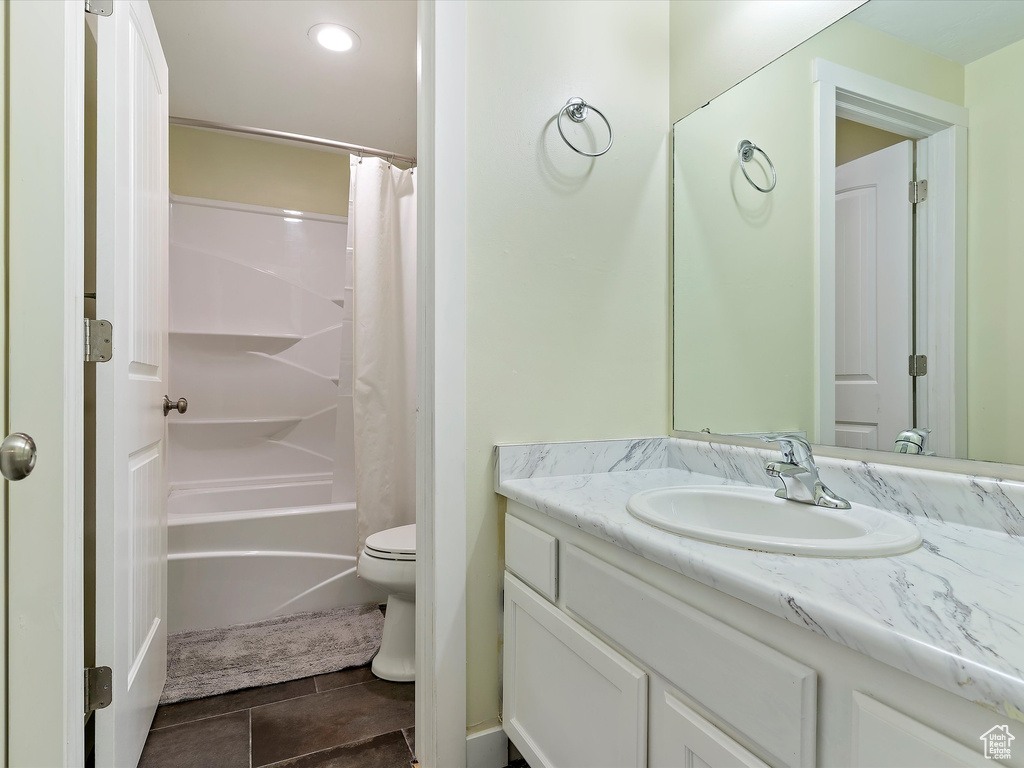 Bathroom featuring vanity, shower / bathtub combination with curtain, toilet, tile patterned floors, and recessed lighting