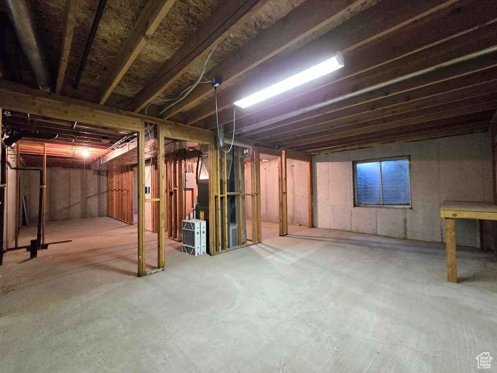 Unfinished below grade area featuring heating unit